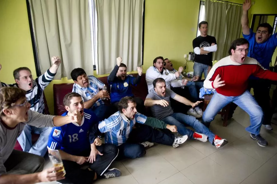 EL MOMENTO JUSTO. Lionel Messi acaba de convertir el gol y la platea estalla de alegría frente al televisor, menos Pablo Décima (el anfitrión) de brazos cruzados.  