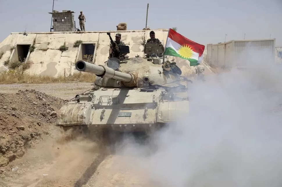 EN EL NORTE. “Peshmergas” kurdos toman posición con un tanque. Las tropas kurdas combaten a los terroristas. reuters