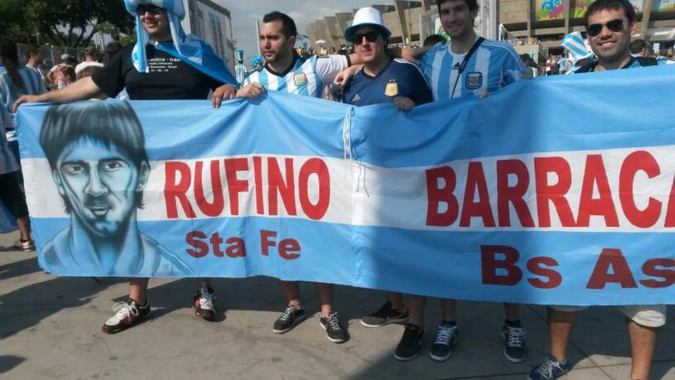 EN BANDA. Enzo García Fiat, el del turbante celeste y blanco, lleva junto a sus amigos una bandera con la imagen de Messi y los nombres de sus lugares en el mundo. 