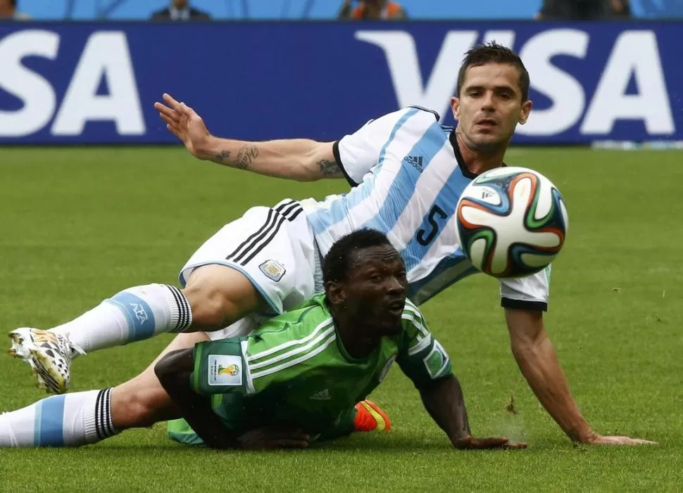 POR EL PISO. Gago se esfuerza para rechazar una pelota ante la presencia de Oshaniwa, durante el primer tiempo del partido que se llevó Argentina por 3 a 2.  