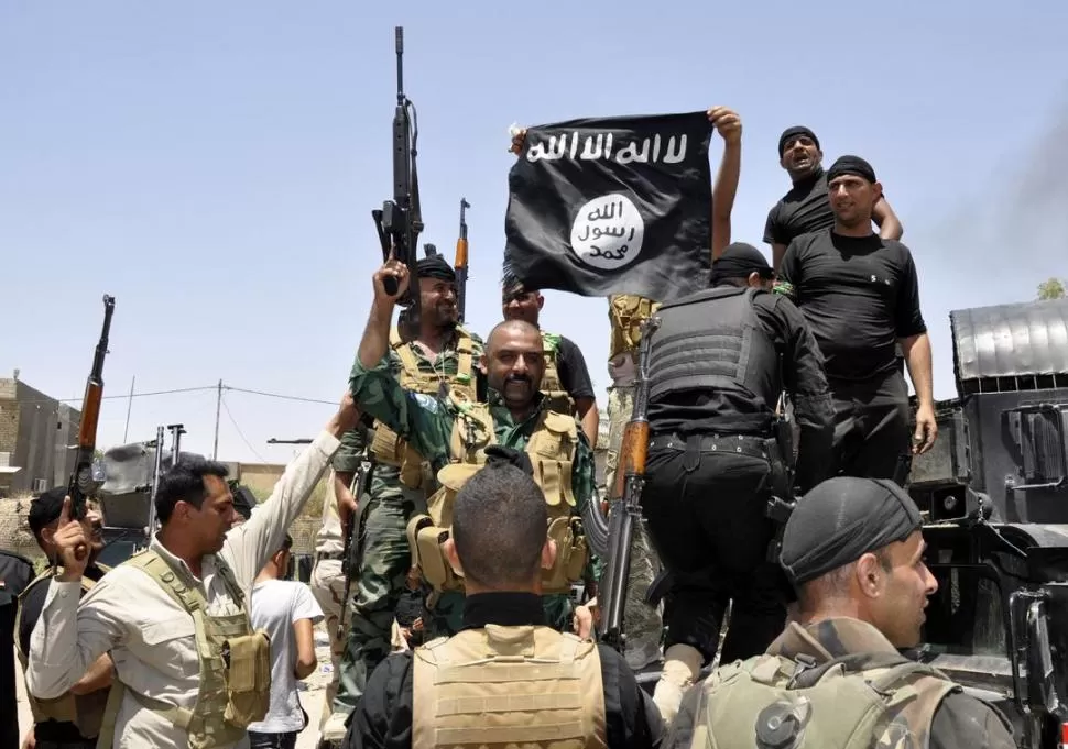 EN DIYALA. Soldados iraquíes muestran como trofeo una bandera del ISIS. reuters