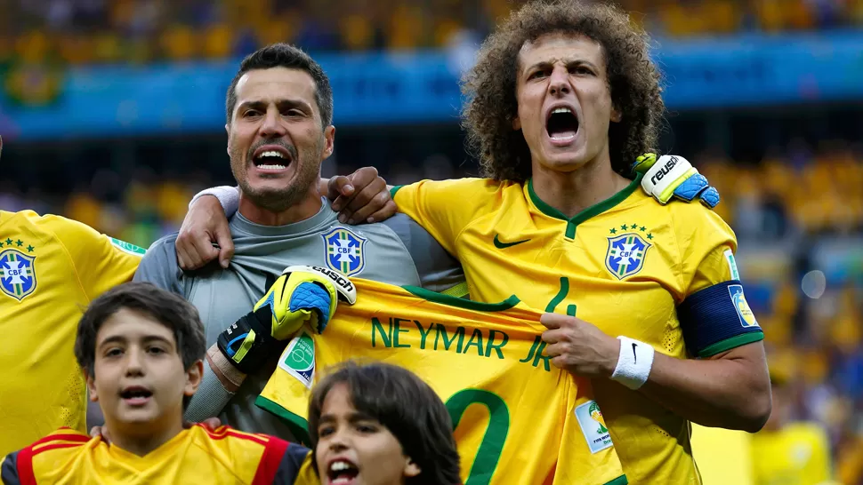 PRESENTE. Los referentes del plantel de Brasil levantaron la camiseta de Neymar durante el himno. REUTERS