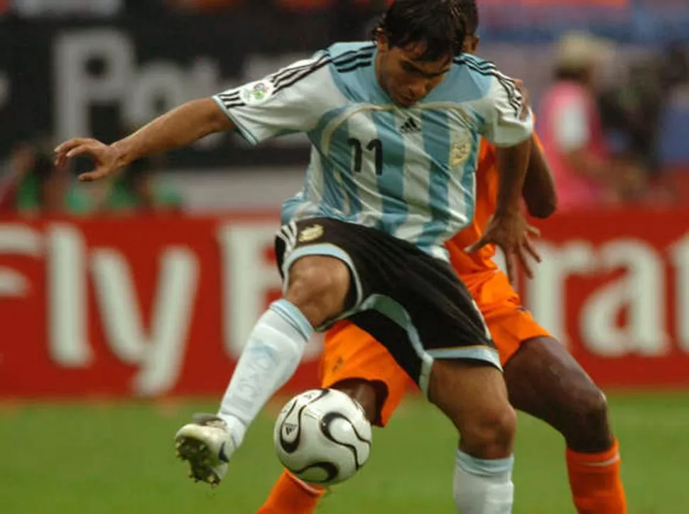 MANO A MANO. “Carlitos” Tevez defiende la bocha de espaldas ante la marca holandesa en el 0 a 0 del Mundial 2006. 