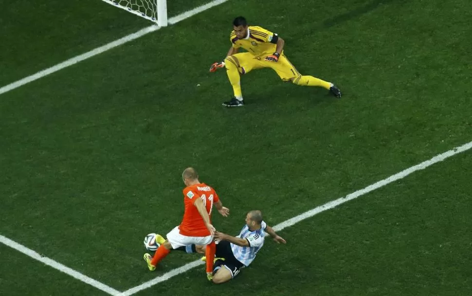 MÁXIMO ESFUERZO. Javier Mascherano, con un gran “timming”, llega con lo justo para tapar el remate del holandés Robben.  