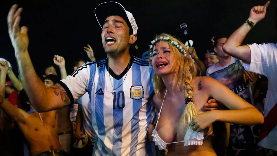 HASTA LAS LÁGRIMAS. Una pareja de argentinos llora en el Fan Fest de Río de Janeiro por la clasificación. REUTERS