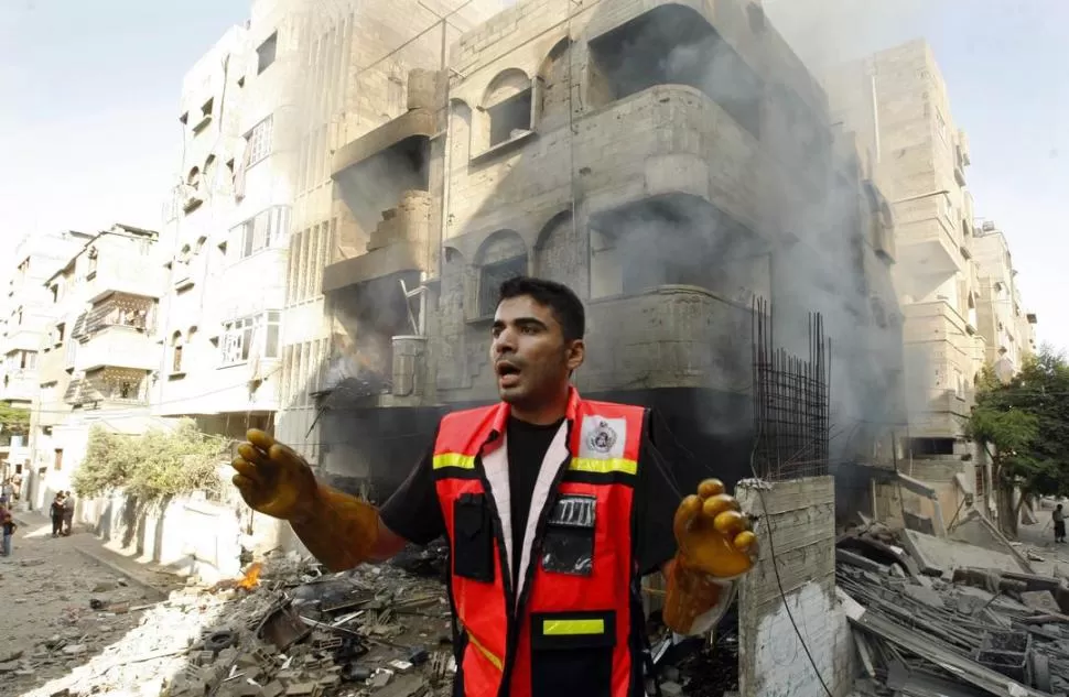 EN GAZA. Un socorrista pide ayuda luego de que una bomba de la aviación israelí impactara en un edificio. REUTERS