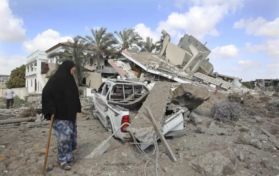 DESTRUCCIÓN. Una palestina camina entre los escombros de una vivienda atacada por la aviación israelí, en Gaza, durante la ofensiva contra Hamas. reiuters