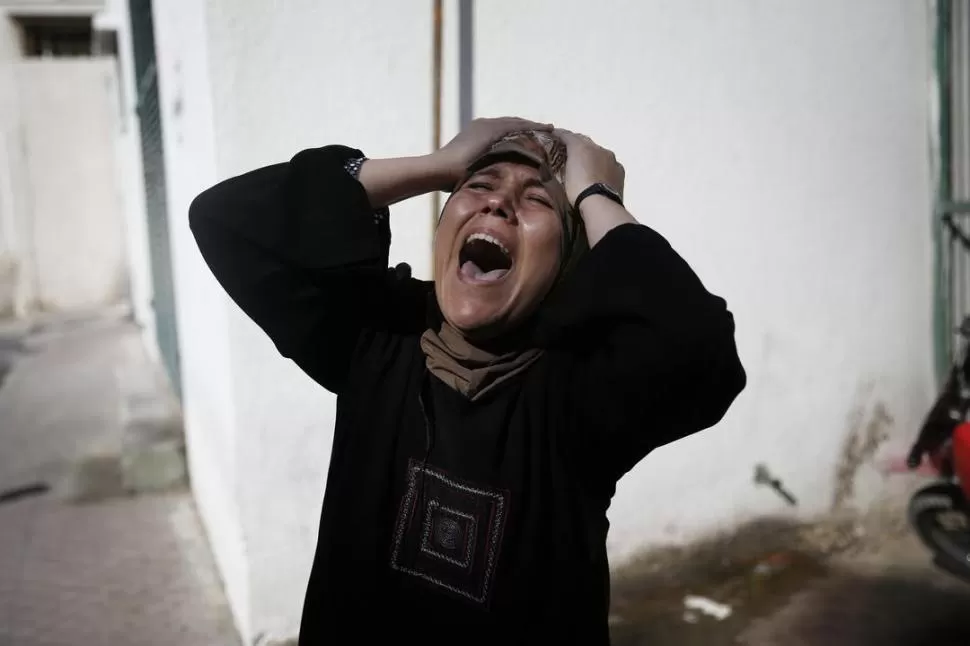 DOLOR. La madre de uno de los niños palestinos que murió en un bombardeo en la playa llora sin consuelo. REUTERS