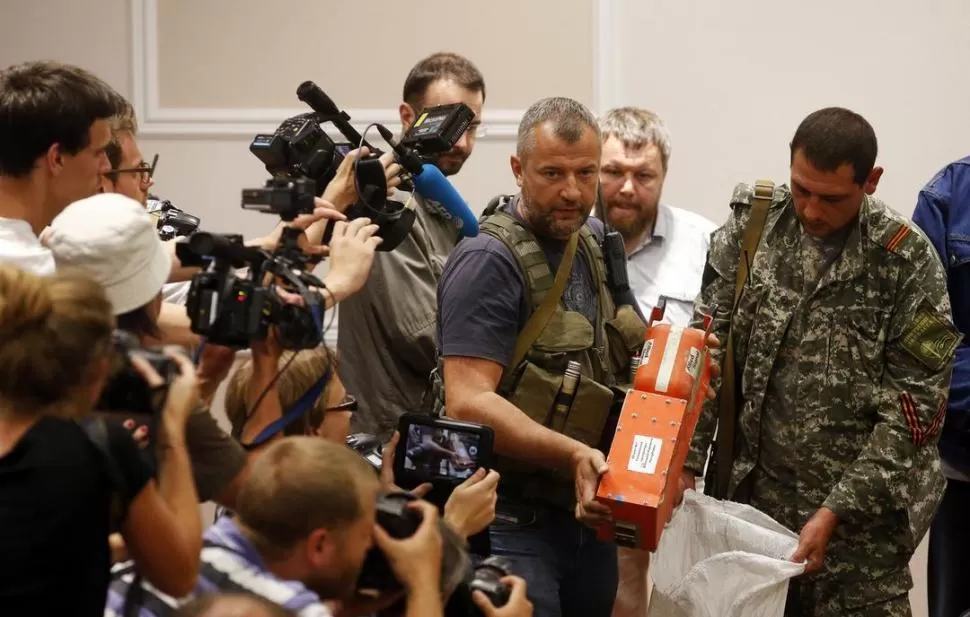 ENTREGA. Un jefe separatista muestra a la prensa las cajas negras, en Járkov. Reuters