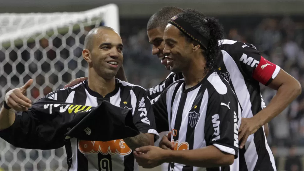 FESTEJO BRASILEÑO. Diego Tardelli anotó su gol número 100 en el partido contra Lanús, y lo festeja junto a sus compañeros, entre ellos Ronaldinho. REUTERS