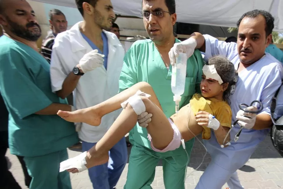 RAFAH. Enfermeros palestinos trasladan a una niña herida en el ataque. REUTERS
