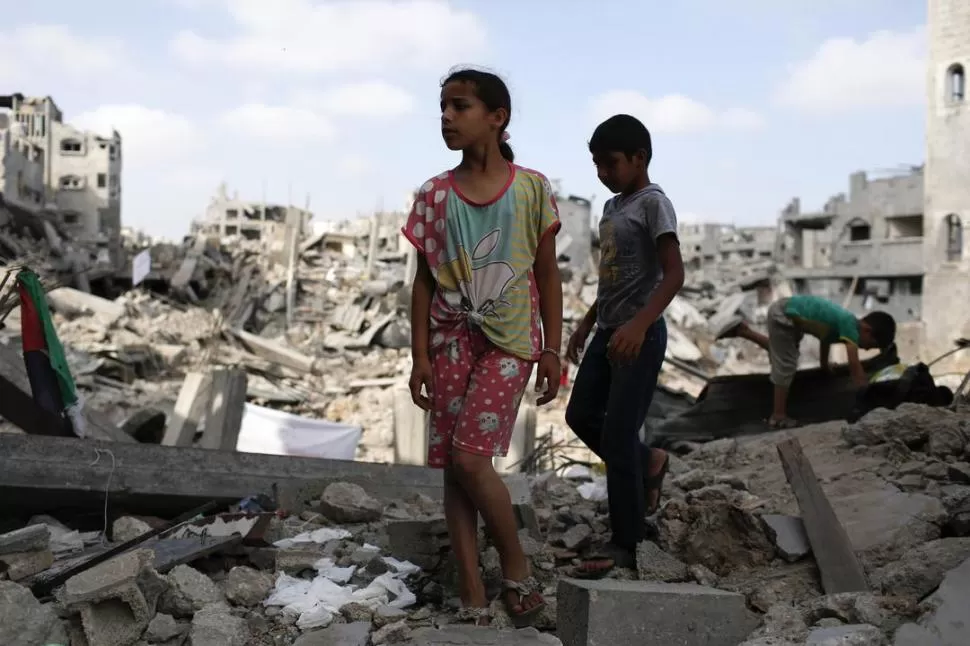 CIUDAD DE GAZA. Niños palestinos deambulan entre las ruinas de su barrio. reuters