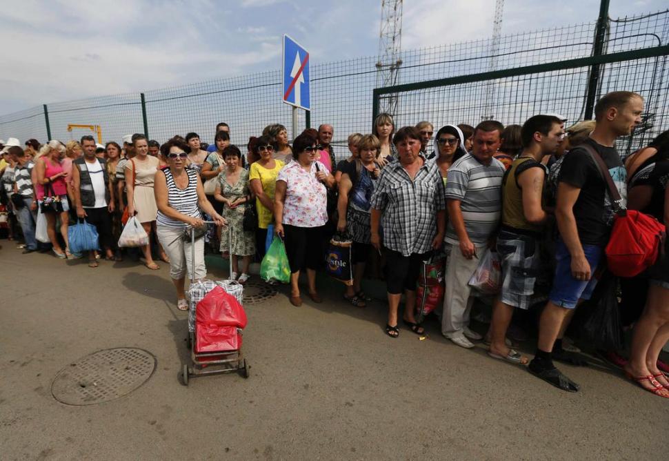 EN LA FRONTERA. Cerca de Donetsk, Este de Ucrania, los pobladores hacen fila para entrar y salir del territorio. reuters