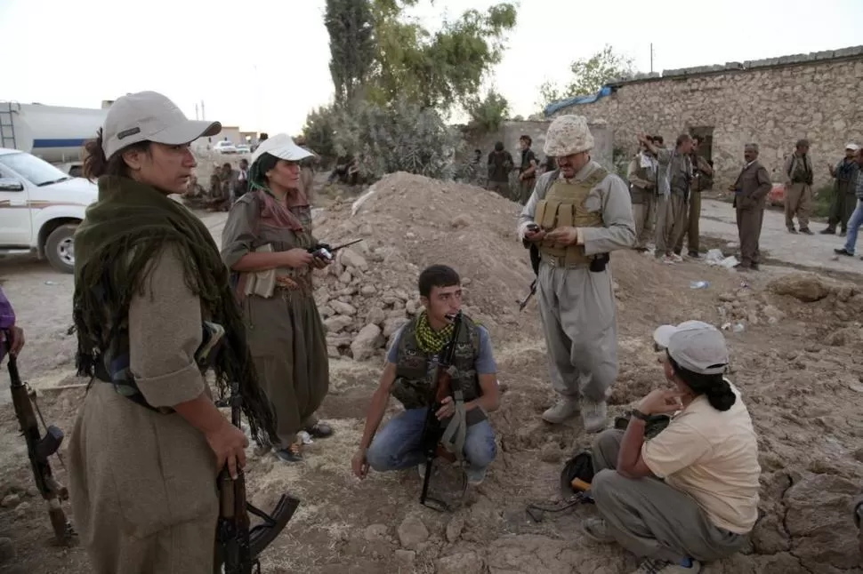 NORTE DE IRAK. Combatientes kurdos (hombres y mujeres) aguardan instrucciones para avanzar sobre el ISIS. reuters