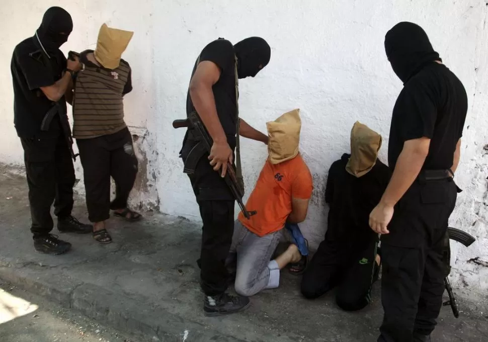 EN EL PAREDÓN. Milicianos de Hamas se aprestan a fusilar a los sospechosos. reuters