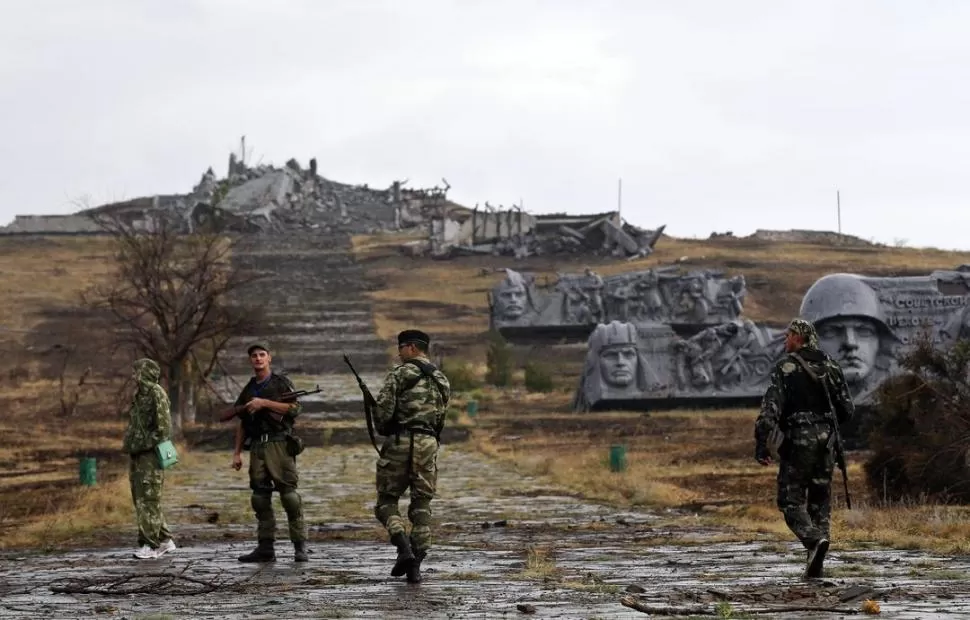 EN DONETSK. Soldados prorrusos patrullan una zona bajo su control, entre el destruido monumento a los caídos, en la colina de Savur-Mohyla. reuters