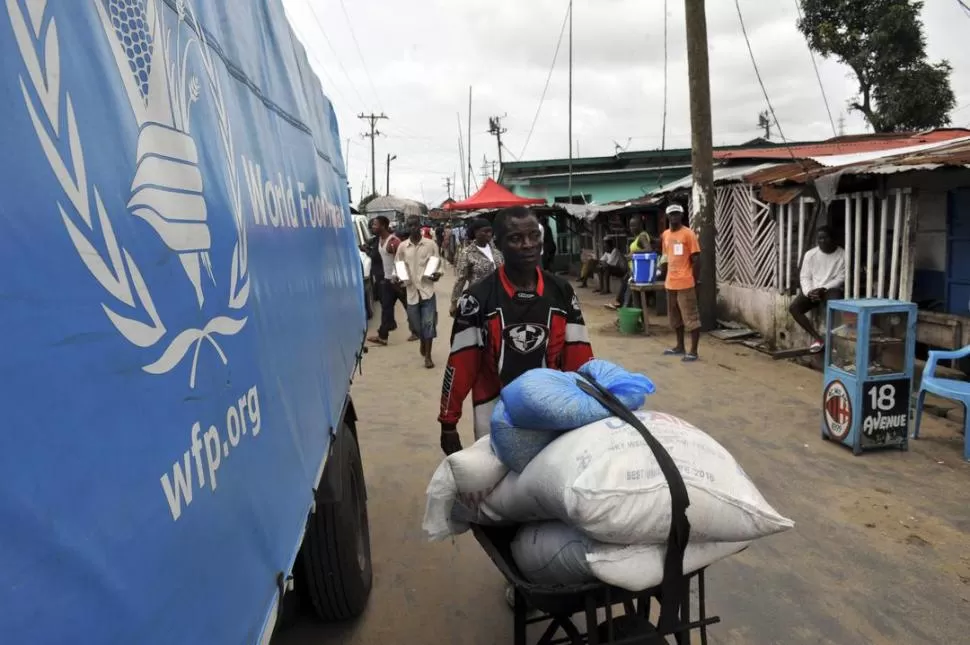 MONROVIA. Liberianos se desplazan por un barrio en cuarentena. reuters