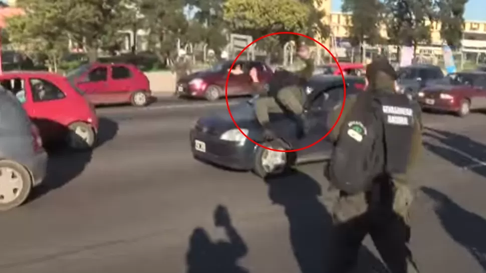 SOBRE EL AUTO. El gendarme se arrojó sobre el auto y luego cayó al pavimento. CAPTURA DE VIDEO