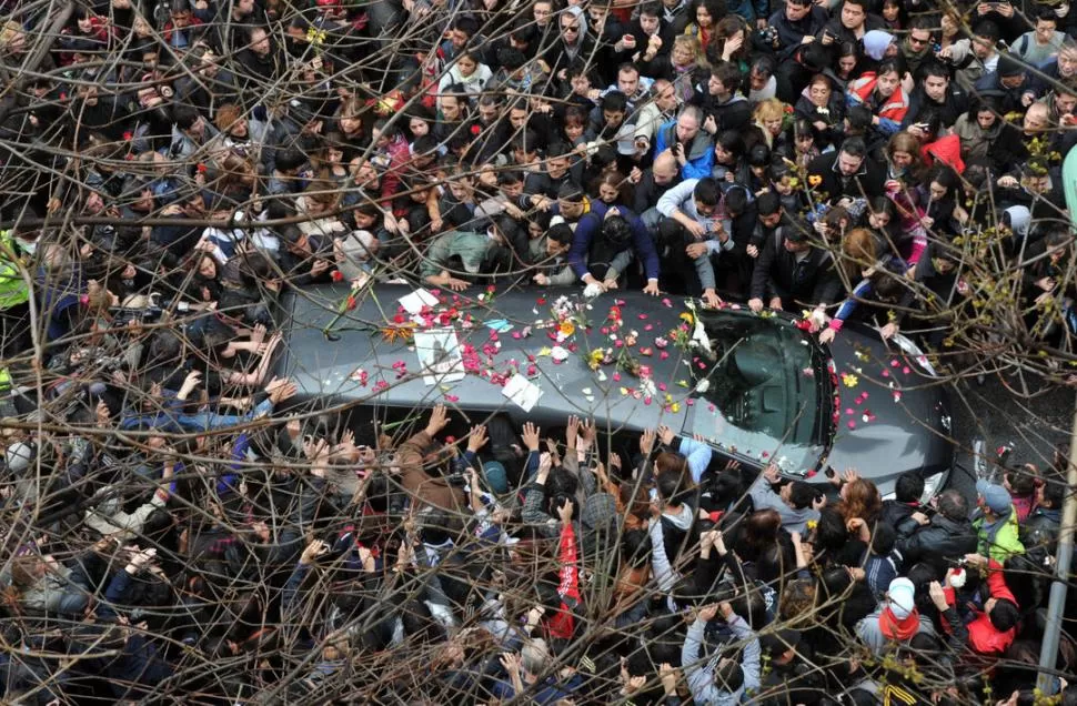MAR DE DOLOR. El coche que traslada a Cerati avanza entre la multitud, que estira sus brazos para despedirlo.  