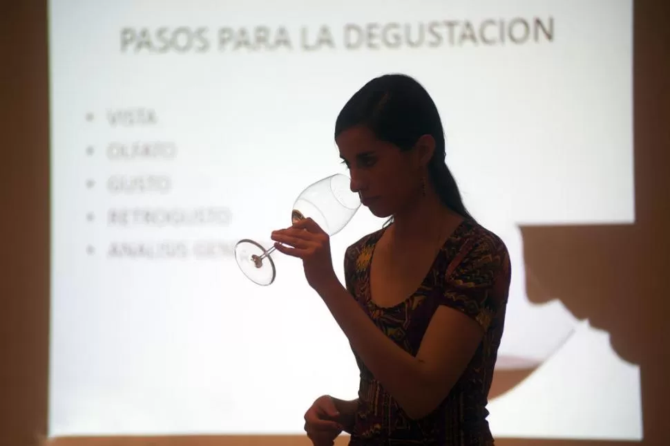 CATA. Tania Höy ejemplifica uno de los pasos para evaluar un vino; la joven enóloga salteña dio una charla y encabezó una degustación en Tucumán.  la gaceta / fotos de diego aráoz