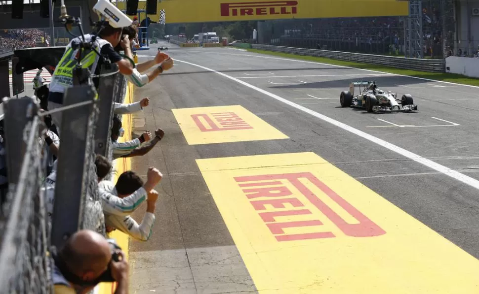 BANDERA A CUADROS. Lewis Hamilton llega a la meta con su Mercedes, saludo por sus mecánicos. El inglés se lució. 