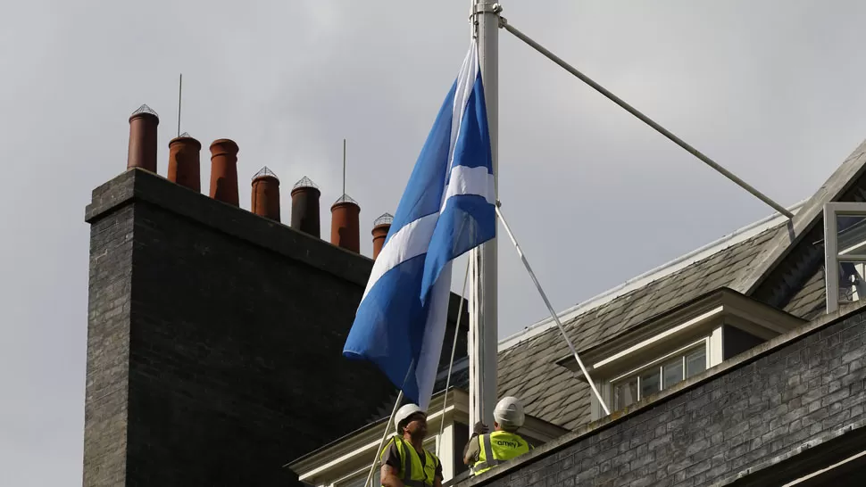 ESPERA. La bandera escocesa es izarda en el edificio donde trabaja el el primer ministro británico. REUTERS