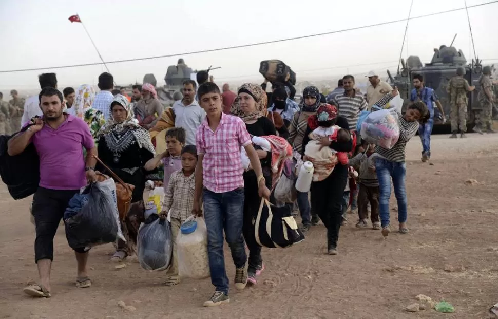LUGARES MÁS SEGUROS. Familias kurdo-sirias huyen del ISIS y buscan refugio en la frontera con Turquía. reuters