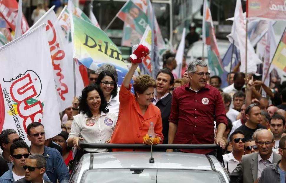EN SANTOS. Dilma Rousseff saluda a sus partidarios desde un vehículo descapotable, durante una recorrida por los barrios del puerto de San Pablo. reuters
