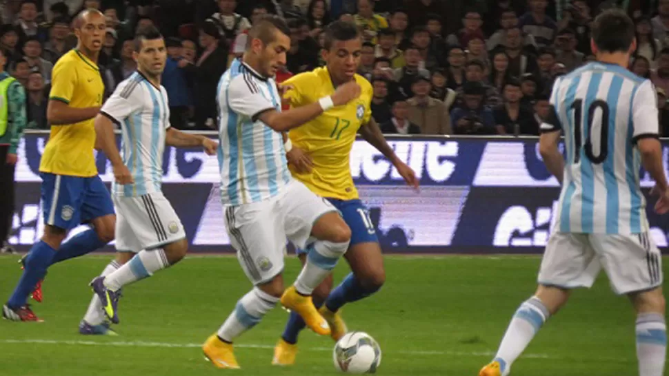 CUMPLIO. Maxi se lleva la pelota ante la marca de Luiz Gustavo y la mirada de Agüero y Messi. DYN