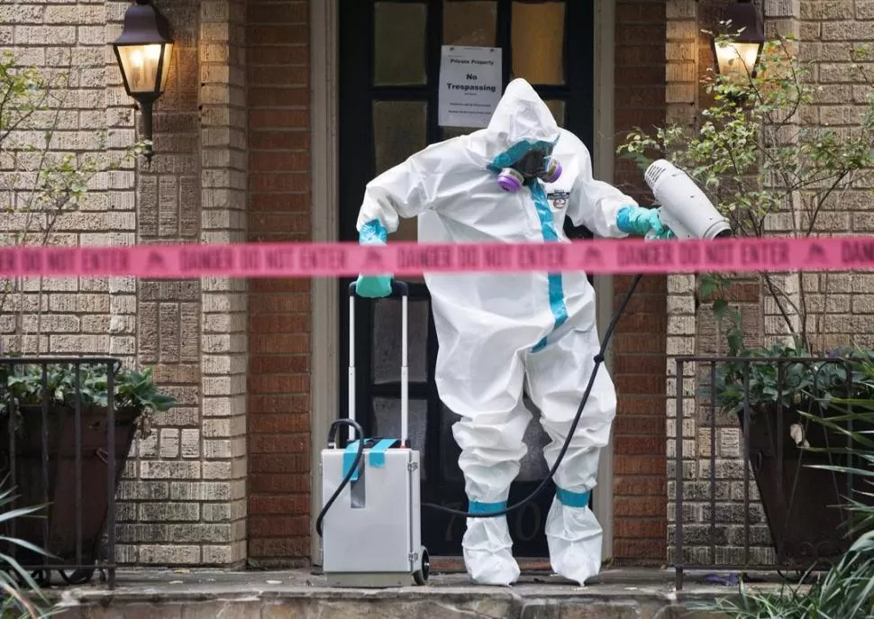 EN TEXAS. Un sanitarista desinfecta la entrada de la casa de una las dos personas que contrajo el ébola en Estados Unidos. reuters