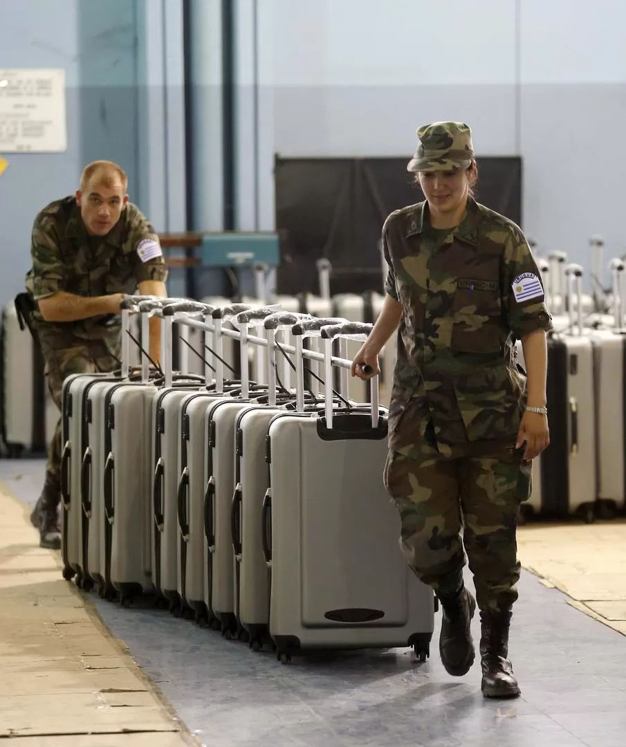 TRASLADO. Soldados uruguayos llevan valijas en las que se encuentran las urnas que será utilizadas en el comicio. reuters