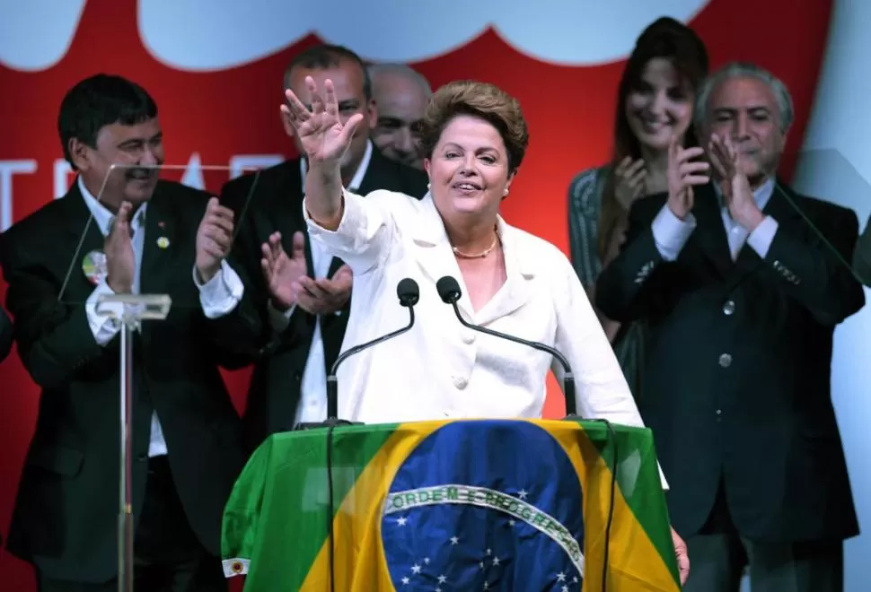 EL FIN DE LA CONTIENDA. Rousseff saluda sus partidarios antes de su discurso, en Brasilia, ocasión en que prometió una reforma política y medidas económicas de “urgencia”. fotos reuters