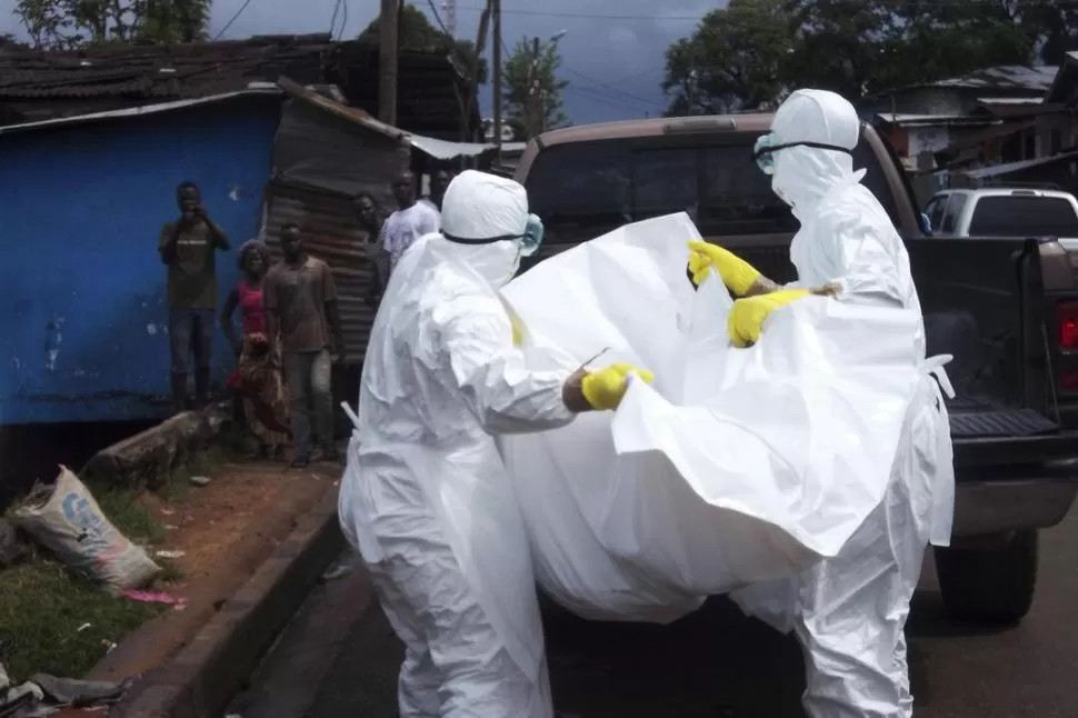MONROVIA. Trabajadores liberianos de la salud trasladan un cadáver. reuters