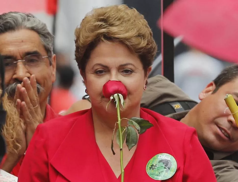 REGALO. Dilma Rousseff huele el perfume de una rosa, que le entregó un simpatizante, en Porto Alegre. reuters