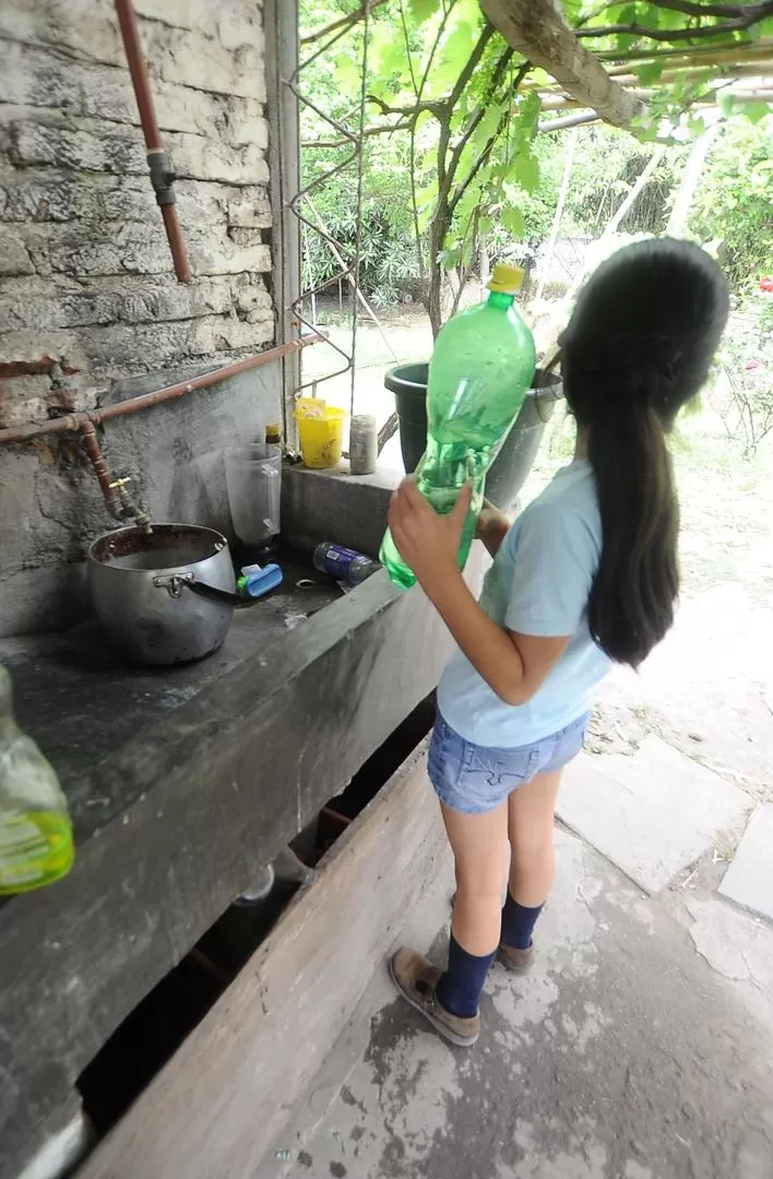 A MANO. Ester Cabrera junta un poco de agua para lavar la ropa. 