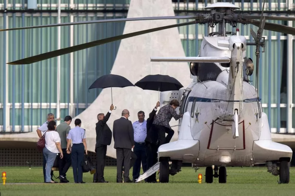 PALACIO ALVORADA. Rousseff sube a un helicóptero para retirarse de la residencia presidencial en Brasilia. reuters
