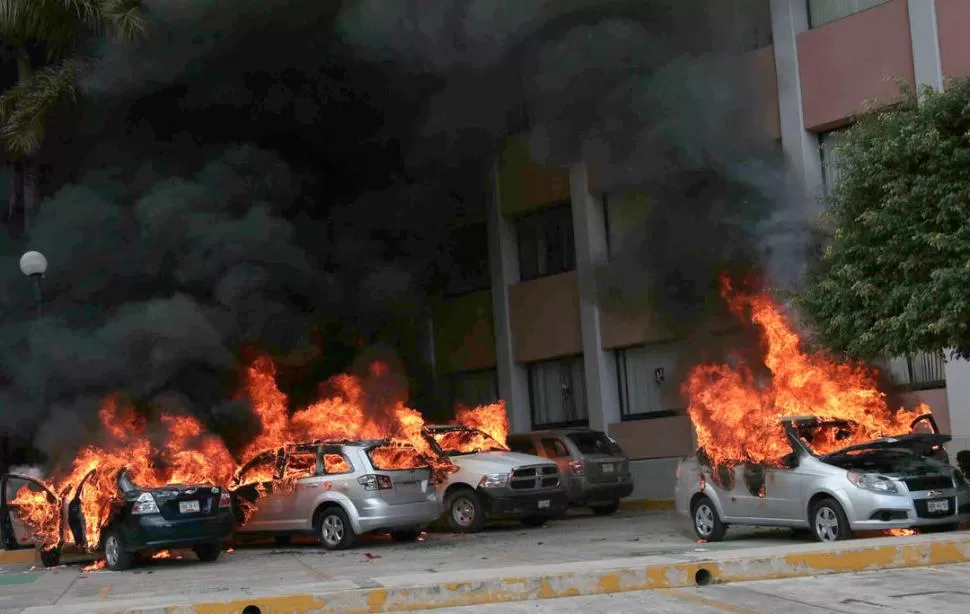 EN CHIPALCINGO. Varios automóviles fueron incendiados, junto a la sede del Congreso de Guerrero, durante una protesta de maestros y familiares de los estudiantes desaparecidos. TELAM
