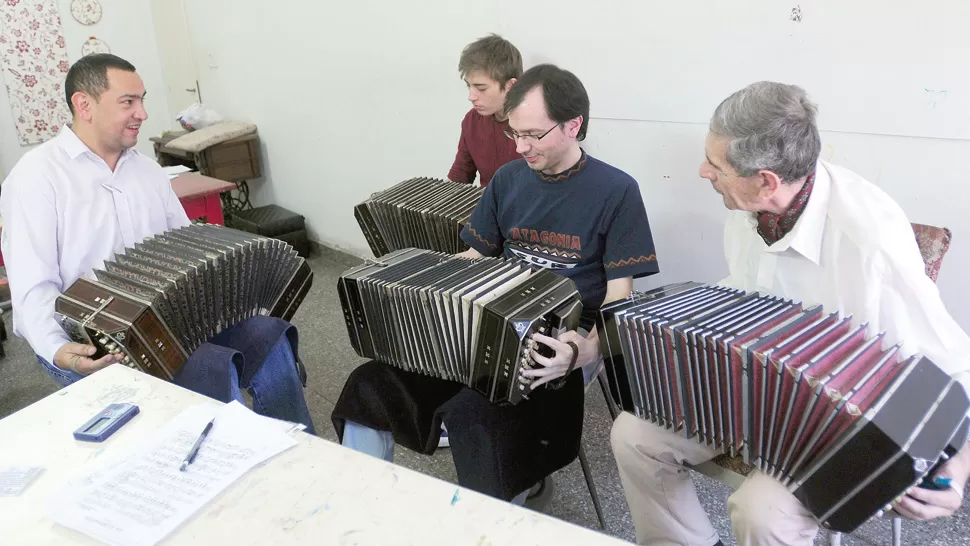 Un maestro que enseña a hacer música con viento entre cuatro paredes