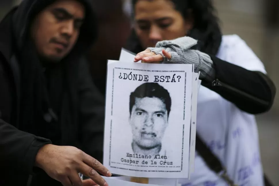 RECLAMO. En Nueva York, familiares de uno de los 43 estudiantes desaparecidos en Iguala muestran su foto, durante una manifestación de protesta. Las marchas para pedir la aparición de los jóvenes se multiplican. reuters