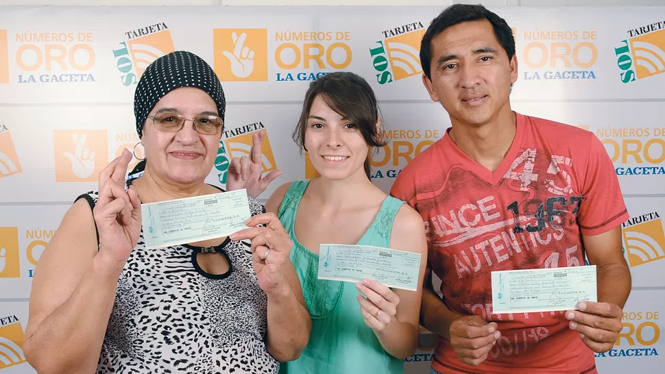 GANADORES. Olga, Antonella y Carlos muestran cheques del premio. LA GACETA / FOTO DE INÉS QUINTEROS ORIO
