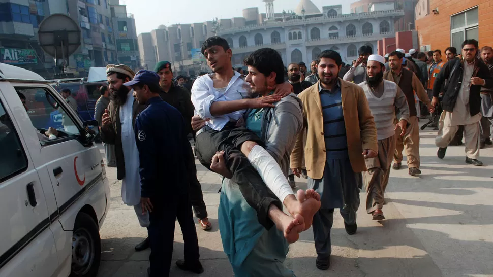 RESCATE. Un adolescente herido es trasladado desde la escuela del ejército, tomada por talibanes. REUTERS