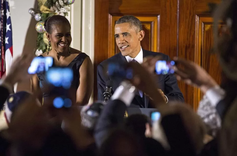 FIESTA. Luego de anunciar el cambio diplomático con Cuba, Obama y su esposa Michelle llegan a una recepción. reuters 