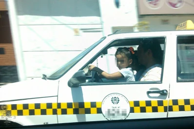 Un taxista fue fotografiado con una nena al volante