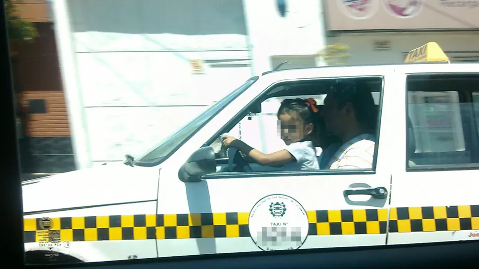 Un taxista fue fotografiado con una nena al volante