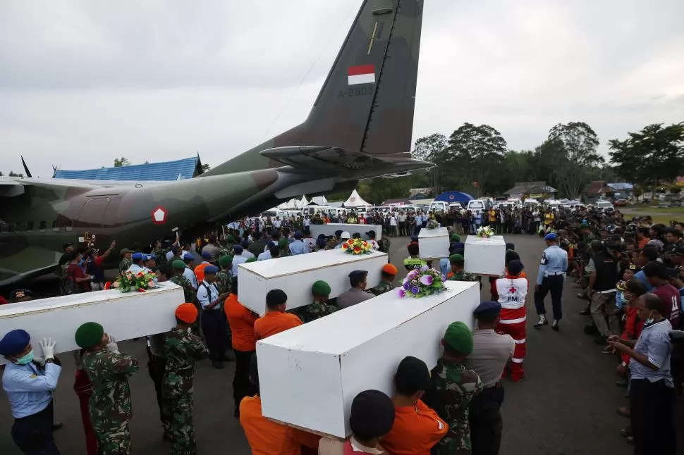 EN SURABAYA. Soldados transportan los ataúdes con los restos de los pasajeros de AirAsia recuperados del mar. reuters