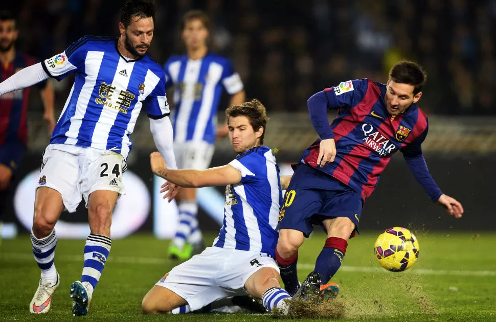 BLOQUEADO. Messi intenta rematar, pero los defensores de Real Sociedad no le dan lugar ni espacio para complicar al arquero Gerónimo Rulli. REUTERS