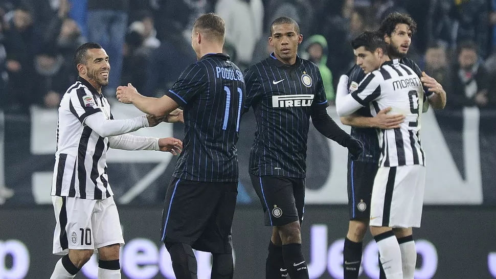 ARGENTINOS GOLEADORES. Carlo Tévez, en la foto saludando a Podolski,convirtió a los 5 minutos del primer tiempo para Juventus, mientras que Mauro Icardi empató a los 19 del segundo tiempo. REUTERS