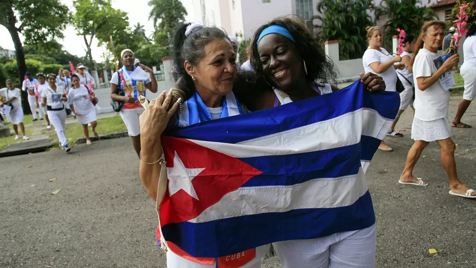 LIBERADAS. Las disidentes Aide Gallardo y Sonia Garro festejan con una bandera cubana, en las calles de La Habana. REUTERS