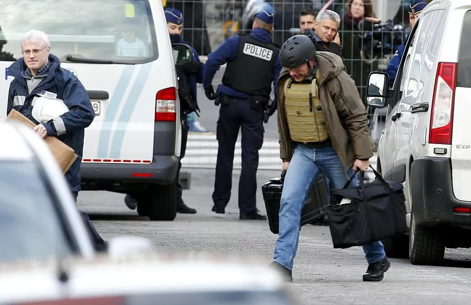 EVIDENCIA. Policías belgas trasladan material secuestrado en el operativo. 