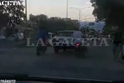 Dos motos, sin patente, empujan un automóvil por la avenida Roca